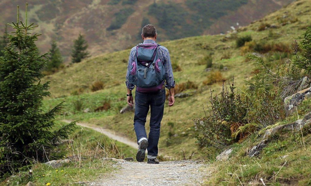 Mann geht auf einem Bergpfad