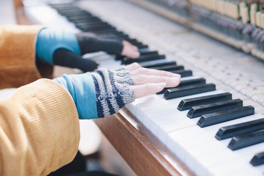 Nahaufnahme der Hände einer Frau beim Klavierspielen