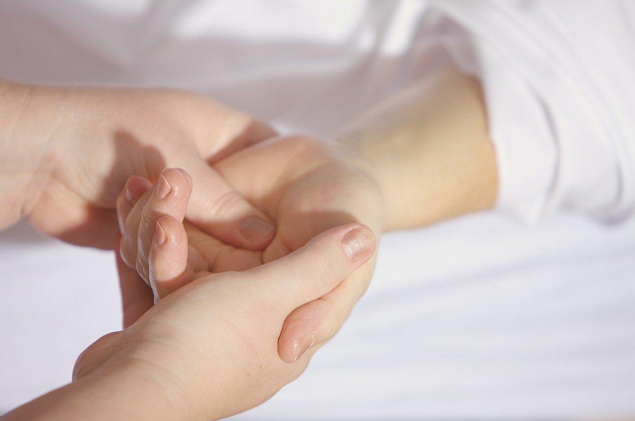 Frau bei der Massage ihrer linken Hand